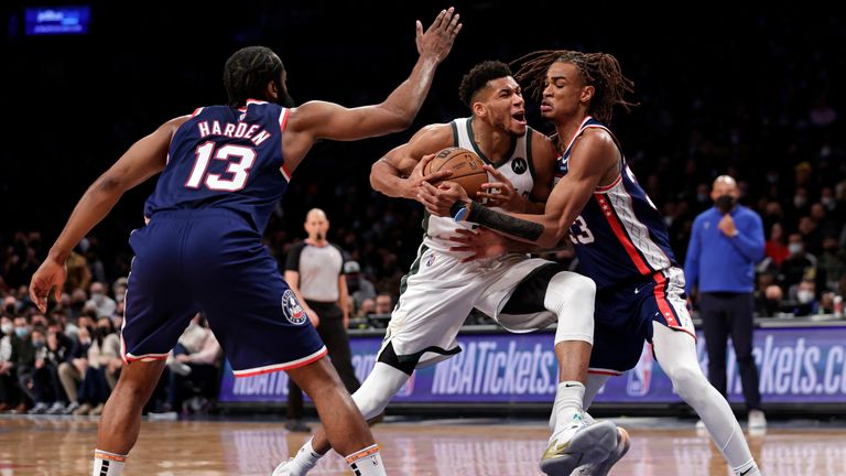 Milwaukee Bucks forward Giannis Antetokounmpo drives to the basket past Brooklyn Nets forward Nic Claxton and James Harden.
