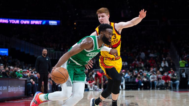 Boston Celtics guard Jaylen Brown (7) dribbles past Atlanta Hawks guard Kevin Huerter (3) during the first half of an NBA basketball game Friday, Jan. 28, 2022, in Atlanta. (AP Photo/Hakim Wright Sr.)