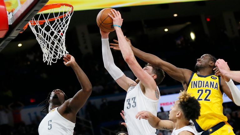Oklahoma City Thunder center Mike Muscala (33) shoots in front of Indiana Pacers guard Caris LeVert (22) and near Oklahoma City Thunder guards Luguentz Dort (5), and Tre Mann, lower right, late in overtime of an NBA basketball game Friday, Jan. 28, 2022, in Oklahoma City. (AP Photo/Nate Billings)