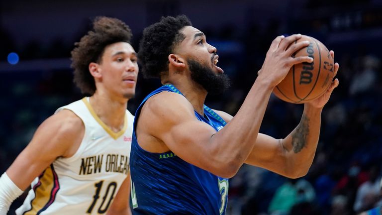 Minnesota Timberwolves center Karl-Anthony Towns (32) goes to the basket against New Orleans Pelicans center Jaxson Hayes (10) in the first half of an NBA basketball game in New Orleans, Tuesday, Jan. 11, 2022. (AP Photo/Gerald Herbert)