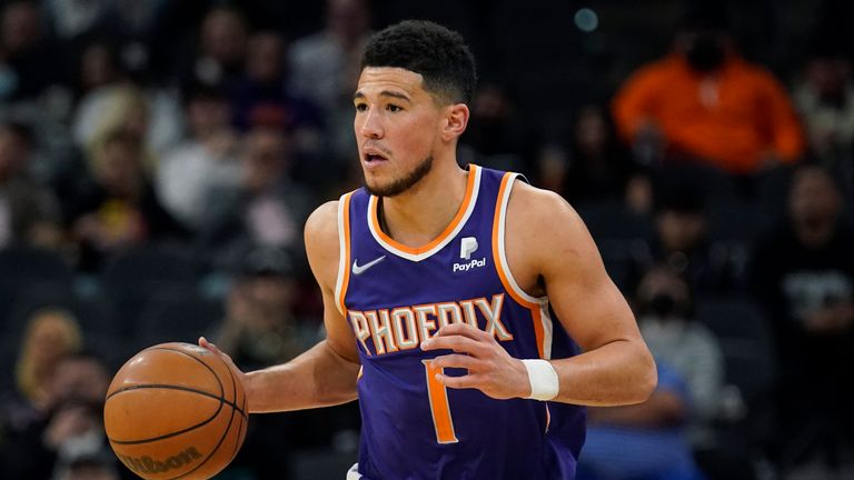 Phoenix Suns guard Devin Booker (1) moves the ball upcourt against the San Antonio Spurs during the second half of an NBA basketball game, Monday, Jan. 17, 2022, in San Antonio.
