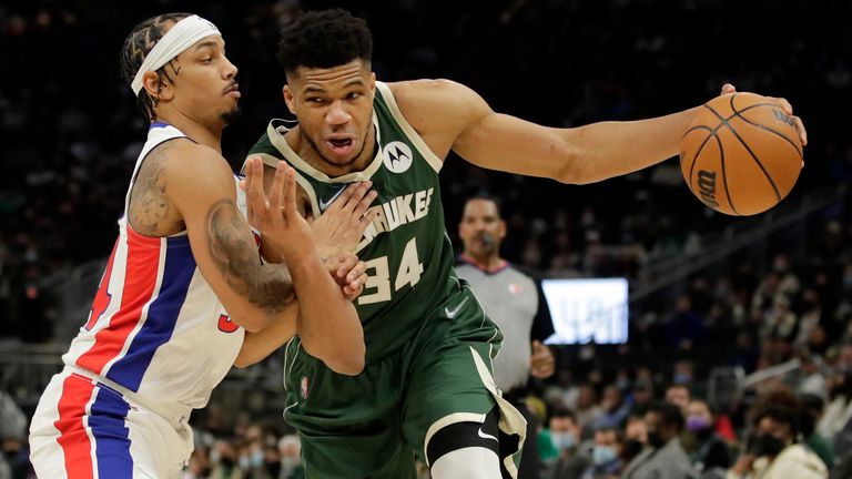 Milwaukee Bucks&#39; Giannis Antetokounmpo, right, drives to the basket against Detroit Pistons&#39; Justin Robinson during the second half of an NBA basketball game Monday, Jan. 3, 2022, in Milwaukee.