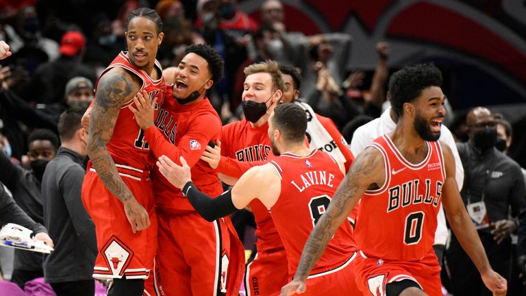 Chicago Bulls forward DeMar DeRozan (11) is mobbed by teammates after he made a game winning three-point basket at the buzzer at the end of an NBA basketball game against the Washington Wizards, Saturday, Jan. 1, 2022, in Washington. The Bulls won 120-119.