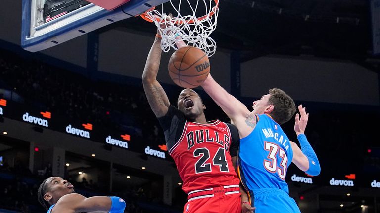 Chicago Bulls forward Javonte Green (24) dunks between Oklahoma City Thunder guard Shai Gilgeous-Alexander, left, and center Mike Muscala (33) in the second half of an NBA basketball game Monday, Jan. 24, 2022, in Oklahoma City. (AP Photo/Sue Ogrocki)


