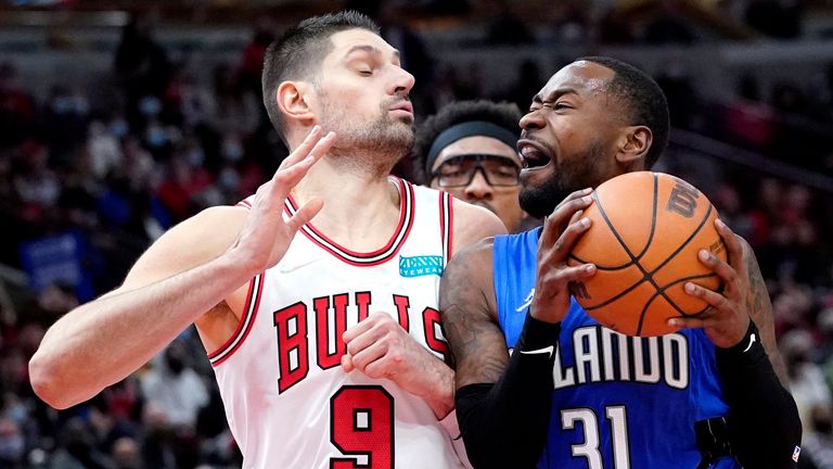 Orlando Magic guard Terrence Ross, right, drives against Chicago Bulls center Nikola Vucevic during the second half of an NBA basketball game in Chicago, Monday, Jan. 3, 2022.