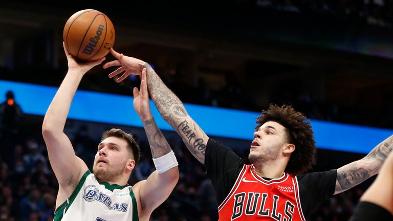 Dallas Mavericks guard Luka Doncic (77) shoots while defended by Chicago Bulls guard Lonzo Ball (2) in the second half of an NBA basketball game in Dallas, Sunday, Jan. 9, 2022. (AP Photo/Tim Heitman)


