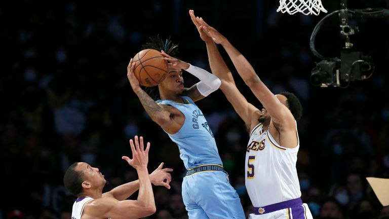 Стражът на Мемфис Гризлис Джа Морант, център, подава топката далеч от натиска на стража на Лос Анджелис Лейкърс Тален Хортън-Тъкър, вдясно, и стража Ейвъри Брадли, вляво, по време на второто полувреме на баскетболен мач от НБА, неделя, 9 януари 2022 г. , в Лос Анджелис. (AP Photo/Alex Gallardo)