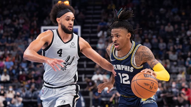 San Antonio Spurs guard Derrick White (4) defends as Memphis Grizzlies guard Ja Morant (12) dribbles the ball during the second half of an NBA basketball game on Friday, December 31, 2021, in Memphis, Tennessee. 