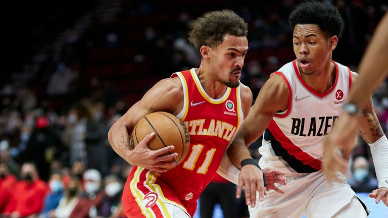 Atlanta Hawks guard Trae Young, left, drives past Portland Trail Blazers guard Anfernee Simons during the first half of an NBA basketball game in Portland, Ore., Monday, Jan. 3, 2022.