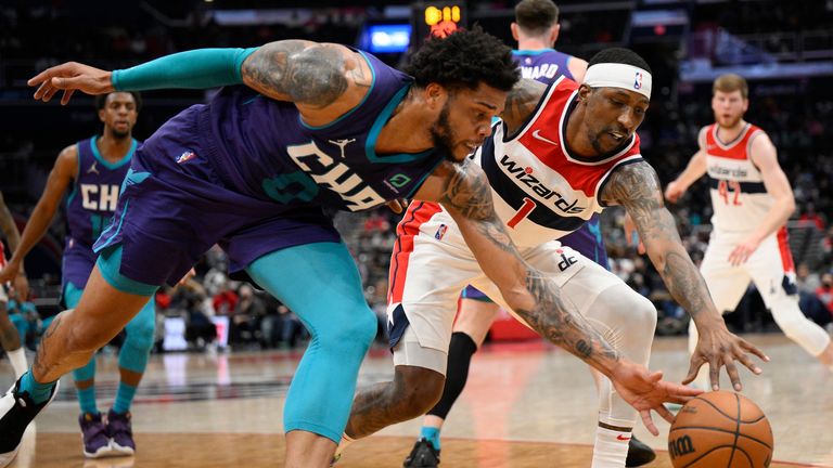 Washington Wizards guard Kentavious Caldwell-Pope (1) and Charlotte Hornets forward Miles Bridges (0) fight for the ball during the first half of an NBA basketball game, Monday, January 3, 2022, in Washington.