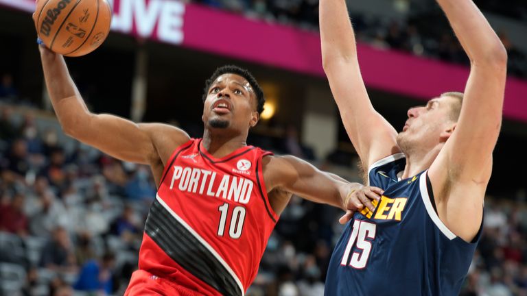 Portland Trail Blazers guard Dennis Smith Jr. drives to the rim as Denver Nuggets center Nikola Jokic defends in the first half of an NBA basketball game Thursday, Jan. 13, 2022, in Denver. 
