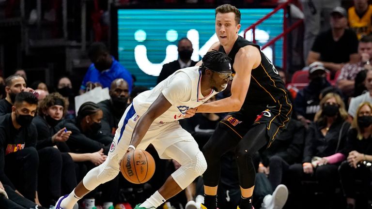 Los Angeles Clippers guard Reggie Jackson, left, drives to the basket as Miami Heat guard Duncan Robinson defend during the first half of an NBA basketball game, Friday, Jan. 28, 2022, in Miami. (AP Photo/Lynne Sladky)