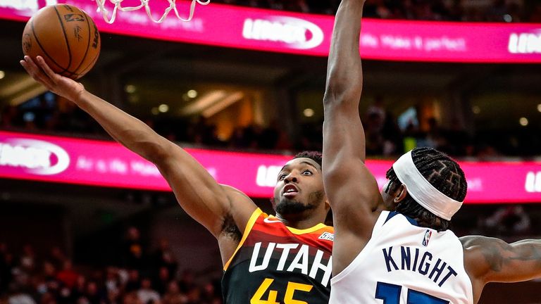 Utah Jazz guard Donovan Mitchell (45) shoots Minnesota Timberwolves striker Nathan Knight (13) during the second half of an NBA basketball game on Friday, December 31, 2021, in Salt Lake City.