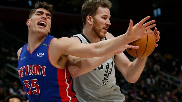 San Antonio Spurs center Jakob Poeltl (25) grabs a rebound against Detroit Pistons center Luka Garza (55) during the first half of an NBA basketball game Saturday, Jan. 1, 2022, in Detroit.
