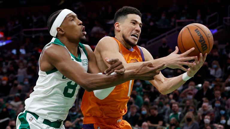 Boston Celtics guard Josh Richardson (8) and Phoenix Suns guard Devin Booker (1) battle for a rebound during the second half of an NBA basketball game, Friday, December 31, 2021, in Boston. 