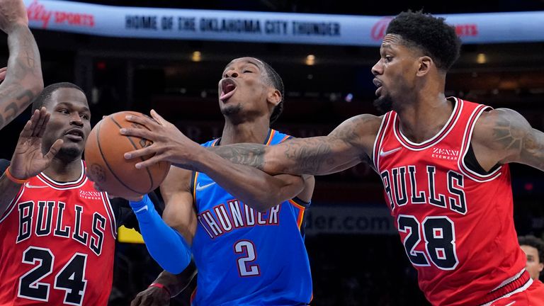 Oklahoma City Thunder guard Shai Gilgeous-Alexander (2) is fouled as he drives between Chicago Bulls forwards Javonte Green (24) and Alfonzo McKinnie (28) in the first half of an NBA basketball game Monday, Jan. 24, 2022, in Oklahoma City. (AP Photo/Sue Ogrocki)


