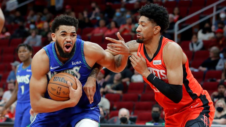 Minnesota Timberwolves center Karl-Anthony Towns, left, drives around Houston Rockets center Christian Wood, right, during the first half of an NBA basketball game Sunday, Jan. 9, 2022, in Houston. (AP Photo/Michael Wyke)


