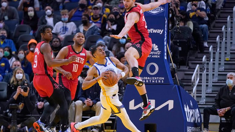 Golden State Warriors guard Jordan Poole, bottom, looks to pass while being defended by Houston Rockets guard Josh Christopher, guard Eric Gordon  and center Alperen Sengun