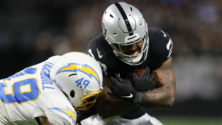 Los Angeles Chargers middle linebacker Drue Tranquill (49) tackles Las Vegas Raiders running back Josh Jacobs (28) during the first half of an NFL football game, Sunday, Jan. 9, 2022, in Las Vegas. (AP Photo/Ellen Schmidt)


