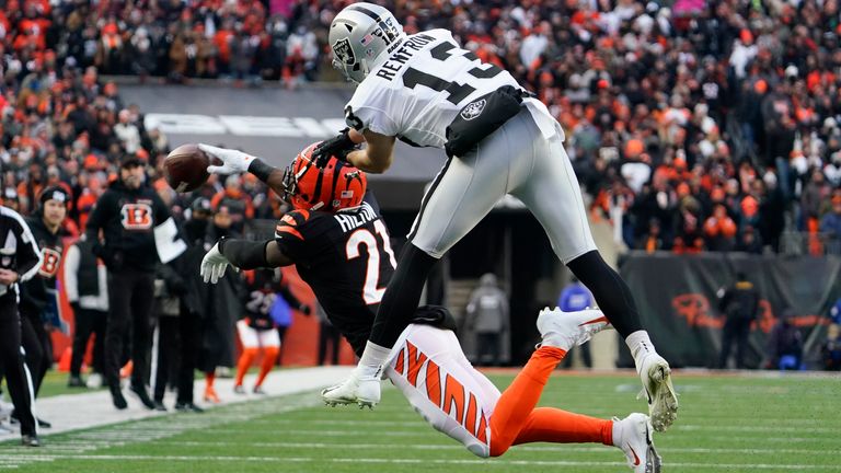 Cincinnati Bengals&#39; Mike Hilton (21) breaks up a pass intended for Las Vegas Raiders&#39; Hunter Renfrow (13) during the first half of an NFL wild-card playoff football game, Saturday, Jan. 15, 2022, in Cincinnati.