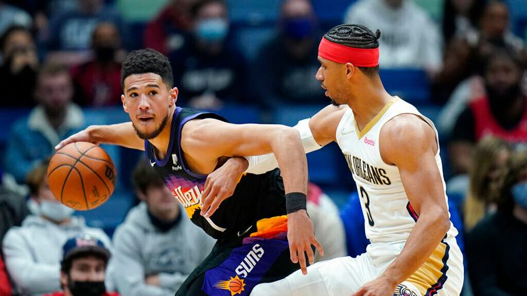 Phoenix Suns guard Devin Booker (1) moves to the basket against New Orleans Pelicans guard Josh Hart (3) in the first half of an NBA basketball game in New Orleans, Tuesday, Jan. 4, 2022. (AP Photo/Gerald Herbert)