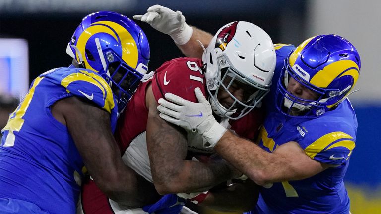 Arizona Cardinals tight end Darrell Daniels, middle, is tackled by Los Angeles Rams defensive end A&#39;Shawn Robinson, left, and inside linebacker Troy Reeder during the second half of an NFL wild-card playoff football game in Inglewood, Calif., Monday, Jan. 17, 2022.