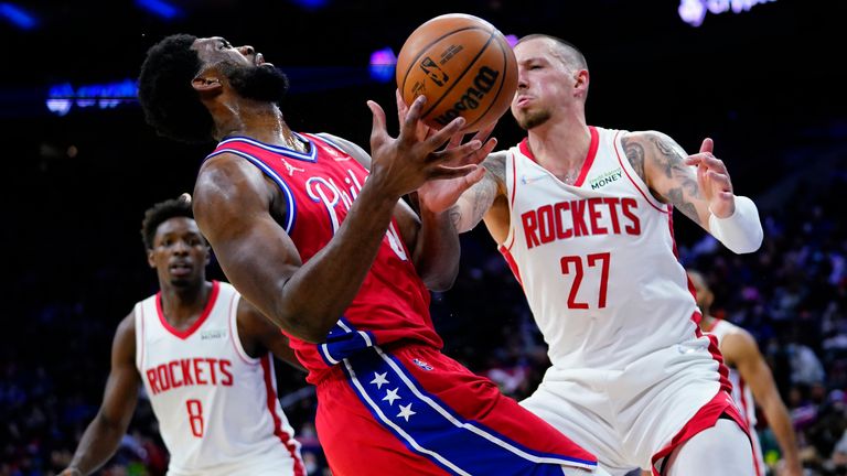 Philadelphia 76ers' Joel Embiid, center, is fouled by Houston Rockets' Daniel Theis, right, during the second half of an NBA basketball game, Monday, Jan. 3, 2022, in Philadelphia.