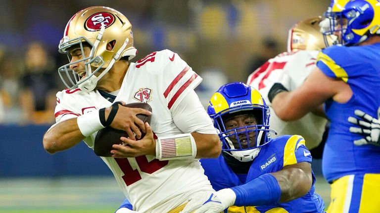 San Francisco 49ers&#39; Jimmy Garoppolo, left, escapes a sack attempt by Los Angeles Rams&#39; Obo Okoronkwo during the second half of the NFC Championship NFL football game Sunday, Jan. 30, 2022, in Inglewood, Calif. (AP Photo/Elaine Thompson)