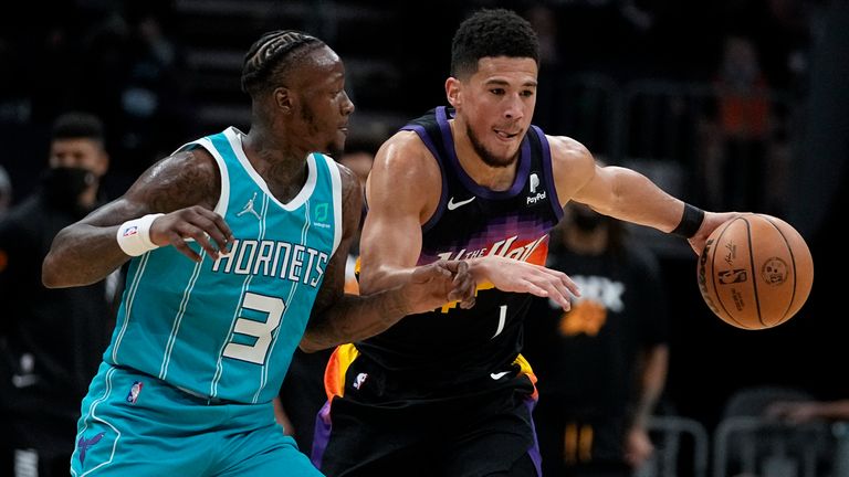 Phoenix Suns guard Devin Booker drives to the basket past Charlotte Hornets guard Terry Rozier