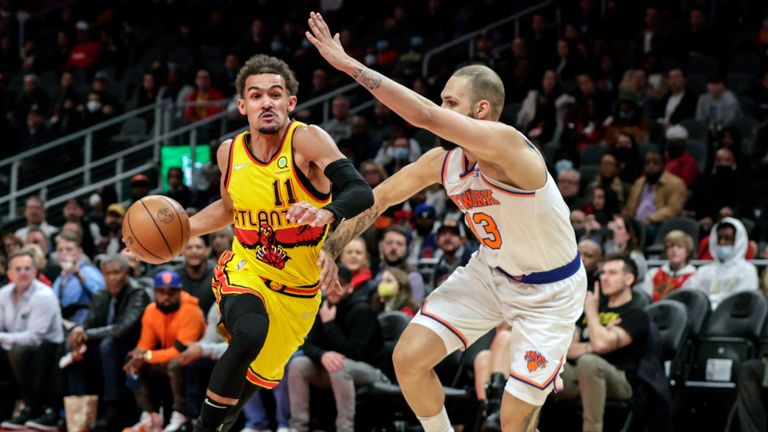 Atlanta Hawks guard Trae Young drives to the basket as New York Knicks guard Evan Fournier defends during the first half of an NBA basketball game Saturday, Jan. 15, 2022, in Atlanta.