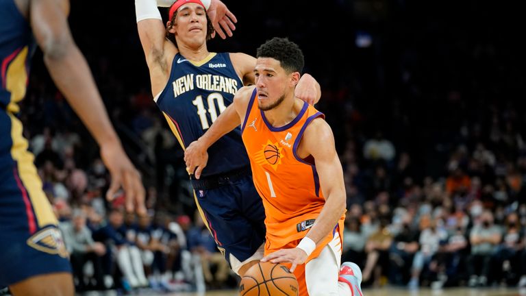 Phoenix Suns guard Devin Booker drives past New Orleans Pelicans center Jaxson Hayes during the second half of an NBA basketball game, Friday, Feb. 25, 2022, in Phoenix. 