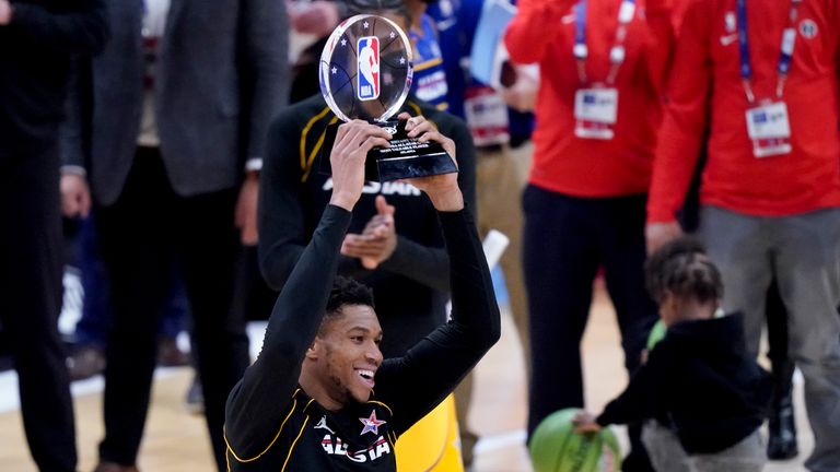 Milwaukee Bucks forward Giannis Antetokounmpo holds up the trophy after basketball&#39;s NBA 2021 All-Star Game in Atlanta