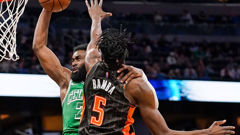 Boston Celtics guard Jaylen Brown, left, dunks the ball over Orlando Magic center Mo Bamba (5) during the second half of an NBA basketball game, Sunday, Feb. 6, 2022, in Orlando, Fla.