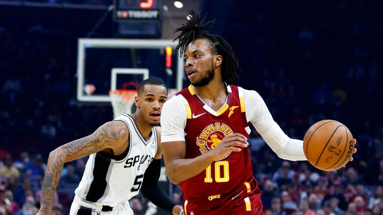 Cleveland Cavaliers' Darius Garland (10) drives against San Antonio Spurs' Dejounte Murray (5) during the first half of an NBA basketball game, Wednesday, Feb. 9, 2022, in Cleveland. (AP Photo/Ron Schwane)