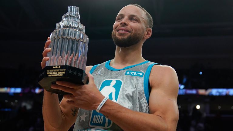 Golden State Warriors&#39; Stephen Curry holds up the Kobe Bryant Trophy after being named the MVP of the NBA All-Star basketball game, Sunday, Feb. 20, 2022, in Cleveland. (AP Photo/Charles Krupa)