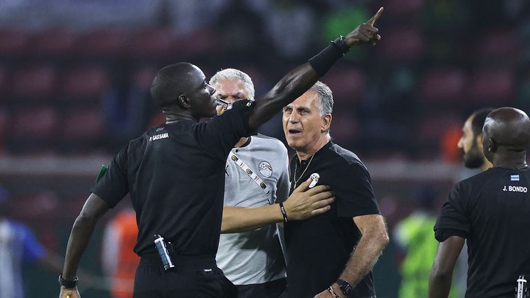 Gambian referee Bakary Gassama (L) gives a red card to Egypt's Portuguese head coach Carlos Queiroz (C) during the Africa Cup of Nations (CAN) 2021 semi-final football match between Cameroon and Egypt at the Stade d 'Olembe in Yaounde on 3 February 2022. 