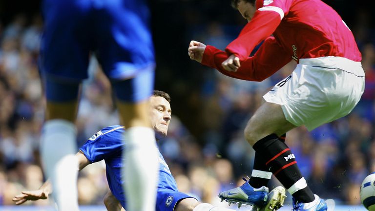 Chelsea's John Terry (C) gets injured in a tackle from Wayne Rooney (R) of Manchester United during the Premiership football match at Stamford Bridge in London 29 April 2006. Chelsea need one point from their remaining games to secure the Premiership title