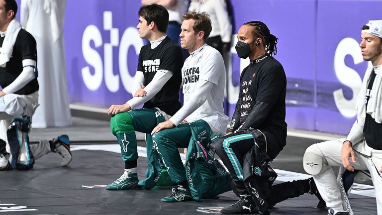 (L-R) Alfa Romeo&#39;s Italian driver Antonio Giovinazzi, Aston Martin&#39;s Canadian driver Lance Stroll, Aston Martin&#39;s German driver Sebastian Vettel, Mercedes&#39; British driver Lewis Hamilton (R) and AlphaTauri&#39;s French driver Pierre Gasly kneel during a tribute to the late founder and former team principal of Williams Racing Frank Williams on the starting grid prior to the Formula One Saudi Arabian Grand Prix at the Jeddah Corniche Circuit in Jeddah on December 5, 2021