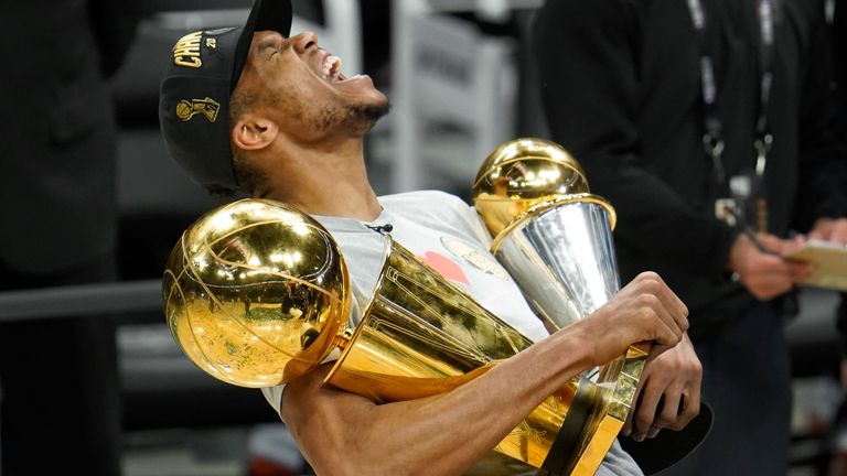 FILE - Milwaukee Bucks forward Giannis Antetokounmpo reacts while holding the NBA Championship trophy, left, and Most Valuable Player trophy after defeating the Phoenix Suns in Game 6 of basketball&#39;s NBA Finals in Milwaukee, Tuesday, July 20, 2021. The Bucks won 105-98. (AP Photo/Paul Sancya, File)