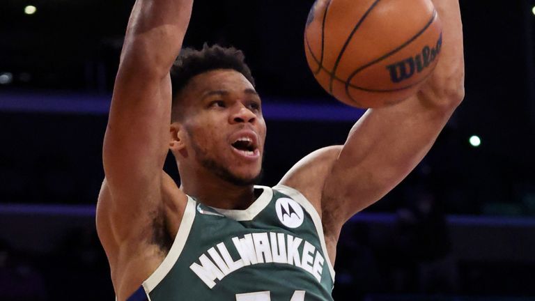 Giannis Antetokounmpo hangs on the rim after throwing down a dunk against the Los Angeles Lakers