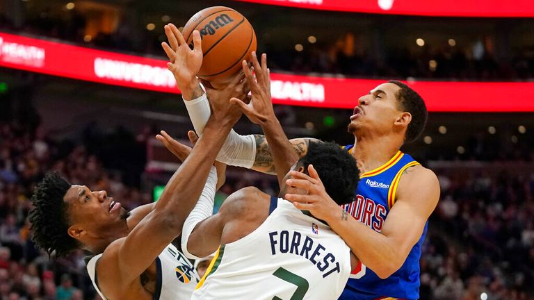 Golden State Warriors forward Juan Toscano-Anderson, right, competes for a rebound against Utah Jazz's Hassan Whiteside, left, and Trent Forrest (3) during the first half of an NBA basketball game Wednesday, Feb. 9, 2022, in Salt Lake City. (AP Photo/Rick Bowmer)