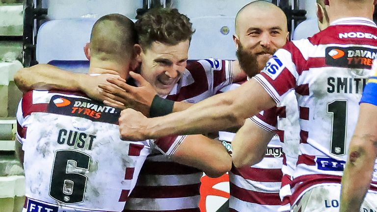 Picture by Alex Whitehead/SWpix.com - 18/02/2022 - Rugby League - Betfred Super League: Round 2 - Wigan Warriors v Leeds Rhinos - The DW Stadium, Wigan, England - Wigan...s Jai Field is congratulated on their try by Cade Cust, Jake Bibby and Morgan Smithies.