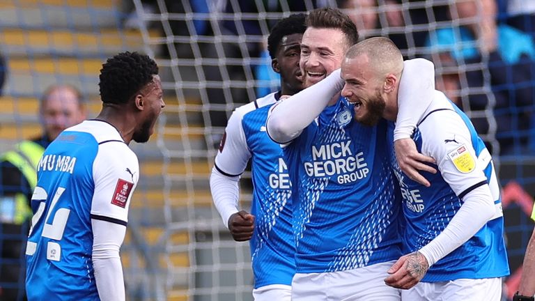 Joe Ward of Peterborough United celebrates with teammates after scoring their teams first goal