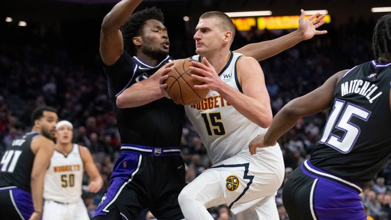 Sacramento Kings center Damian Jones, left, guards Denver Nuggets center Nikola Jokic (15) during the first quarter of an NBA basketball game in Sacramento, Calif., Thursday, Feb. 24, 2022. 