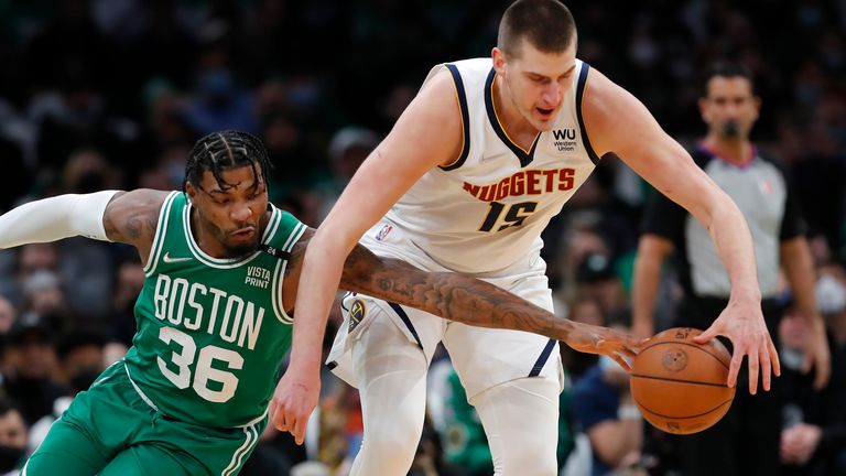 Boston Celtics&#39; Marcus Smart reaches in on Denver Nuggets&#39; Nikola Jokic during the first half of an NBA basketball game Friday, Feb. 11, 2022, in Boston.