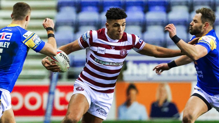 Picture by Alex Whitehead/SWpix.com - 18/02/2022 - Rugby League - Betfred Super League: Round 2 - Wigan Warriors v Leeds Rhinos - The DW Stadium, Wigan, England - Wigan’s Kai Pearce-Paul is tackled by Leeds’ Aidan Sezer.