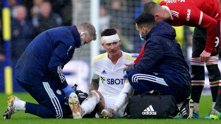Leeds United's Robin Koch receives medical treatment for a head injury (AP)