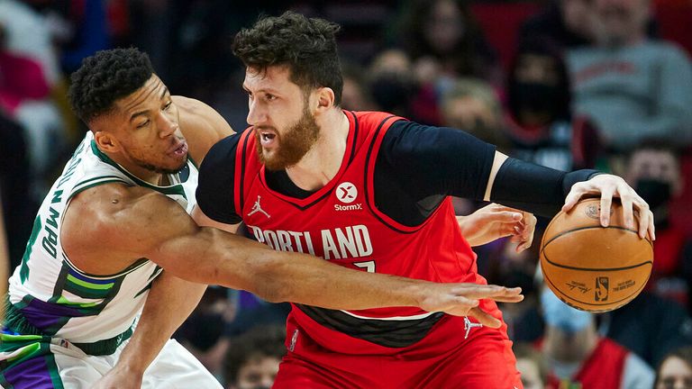 Milwaukee Bucks forward Giannis Antetokounmpo, left, reaches for the ball dribbled by Portland Trail Blazers center Jusuf Nurkic during the first half of an NBA basketball game in Portland, Ore., Saturday, Feb. 5, 2022. (AP Photo/Craig Mitchelldyer)
