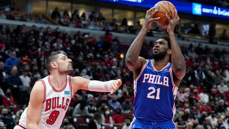 Philadelphia 76ers center Joel Embiid, right, drives to the basket against Chicago Bulls center Nikola Vucevic during the first half of an NBA basketball game in Chicago, Sunday, Feb. 6, 2022