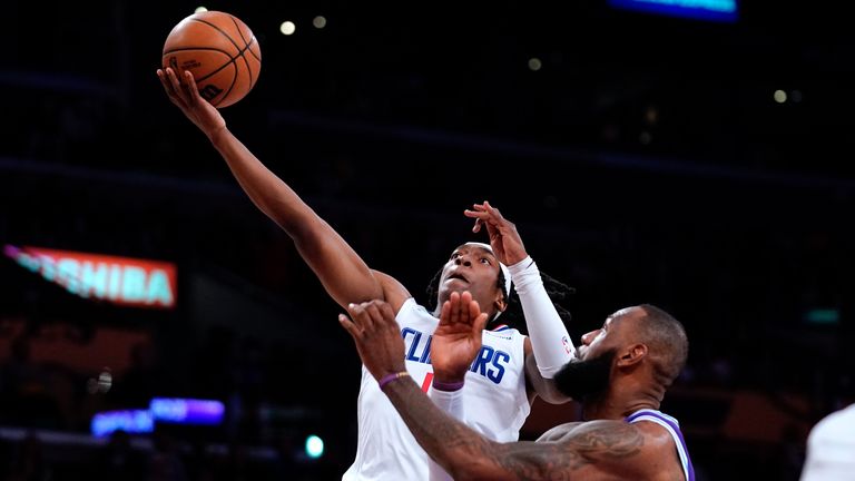 Los Angeles Clippers guard Terance Mann, left, shoots as Los Angeles Lakers&#39; Lebron James defends during the first half of an NBA basketball game Friday, Feb. 25, 2022, in Los Angeles.